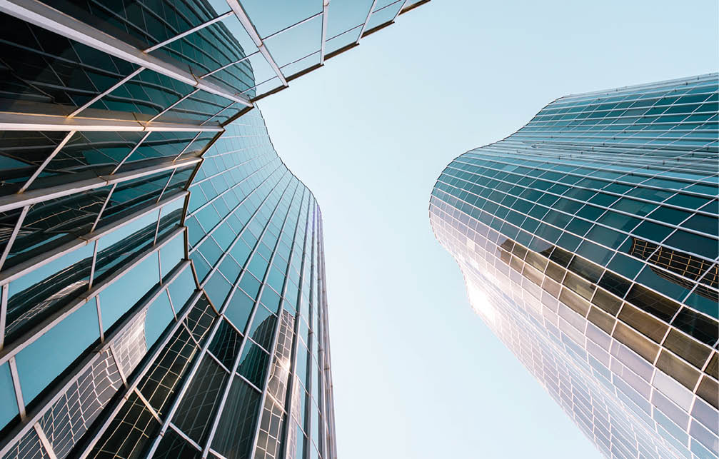Low angle view of a curved building with glass and steel facade in Barcelona, Spain.
