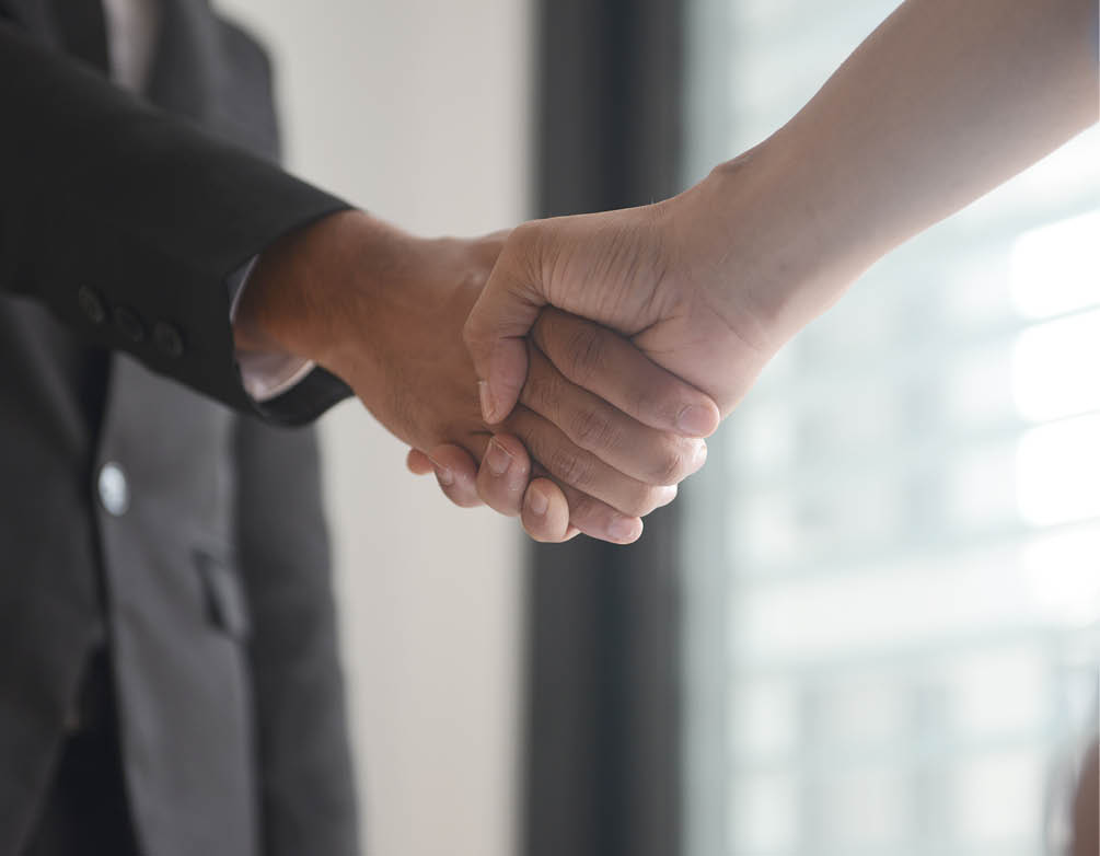 Real estate agent shakes hand with home buyer inside of newly purchased house in Kuala Lumpur, Malaysia
