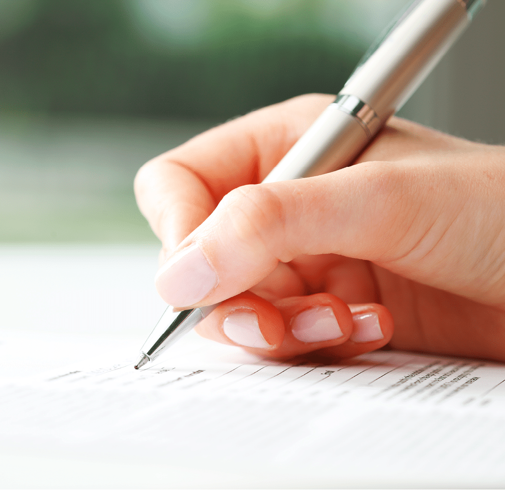 Businesswoman's hand with pen completing personal information on a form