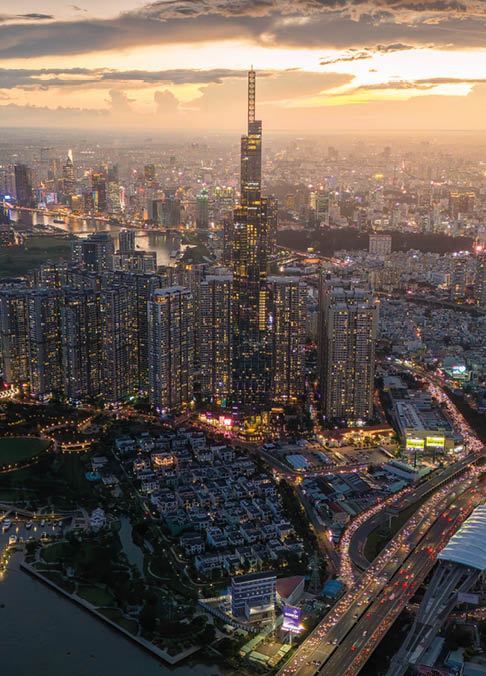 Aerial sunset view at Landmark 81 - it is a super tall skyscraper and Saigon bridge with development buildings along Saigon river, cityscape in the night. Travel and business concept